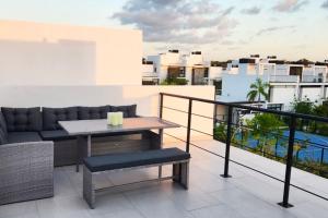 a balcony with a couch and a table on a roof at 2bd Tulum Country ClubPGA golfMid termgrocery in Akumal
