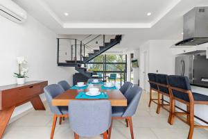 a dining room with a wooden table and blue chairs at 2bd Tulum Country ClubPGA golfMid termgrocery in Akumal