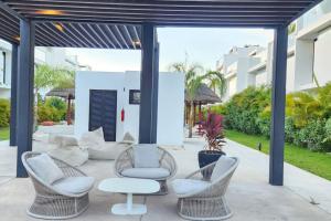 a patio with white chairs and tables and a building at 2bd Tulum Country ClubPGA golfMid termgrocery in Akumal