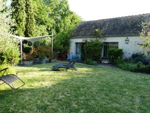 a yard with two benches in front of a house at La Closerie DAUVILLIERS in Roinville