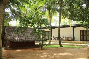 a building with palm trees in front of it at Ariya Tissa in Tissamaharama