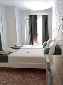 a bedroom with a large bed in front of a window at LITO STUDIOS APARTMENTS in Pythagoreio