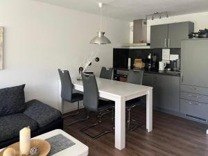 a kitchen and living room with a white table and chairs at Tgesa Tgampi T20 in Savognin