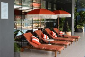 a row of chairs with umbrellas in a building at DDK Collection Hotel in Duhok