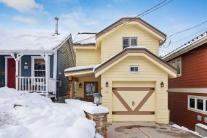 a house with a garage in the snow at Cozy Hillside Cottage Overlooking Main Street in Park City