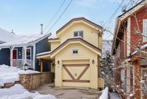 a house with a garage in the snow at Cozy Hillside Cottage Overlooking Main Street in Park City +41 photos