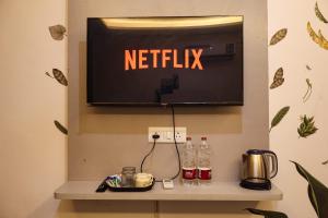 a netflix sign on a wall with bottles on a shelf at Amara Inn by Sandane Homes Near Expo mart and Pari Chowk in Greater Noida +30 photos