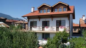 a large white house with a brown roof at Guest House Garbevi in Dobrinishte