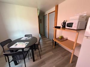 a small room with a table and a microwave at Le chant des oiseaux chambre pour quatre à quelques minutes de la Baie de Somme entre nature mer et télétravail in Nibas
