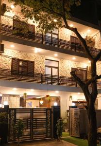 a building with a tree in front of it at Amara Inn by Sandane Homes Near Expo mart and Pari Chowk in Greater Noida