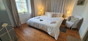 a bedroom with a large white bed and a chair at Boutiquezimmer Duchesse in Mirepoix