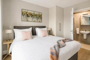 a bedroom with a large white bed and a sink at The Maltings in Portlaoise