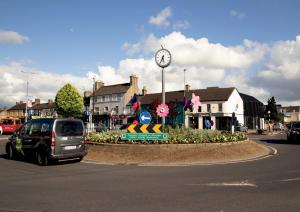 a car parked in front of a roundabout with a clock at The Maltings in Portlaoise