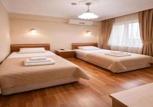 a bedroom with two beds and a window at Coskun Otel Şarköy in Şarköy