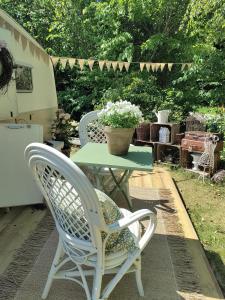 a table with two chairs and a table with a potted plant at The running Rabbit caravan in Ystad +5 photos