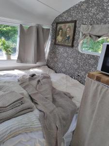 a bed with a blanket on it in a bedroom at The running Rabbit caravan in Ystad