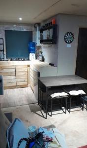 a kitchen with a table and two stools in it at Cabaña Ecologica Huinganes in Machalí