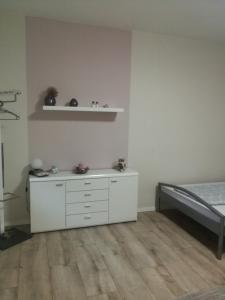 a bedroom with a white dresser and a bed at Lindenblüte in Seehausen +4 photos