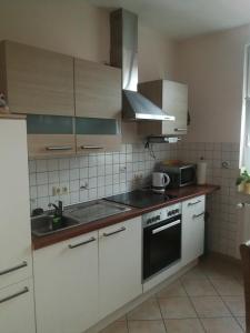 a kitchen with white cabinets and a sink and a stove at Lindenblüte in Seehausen