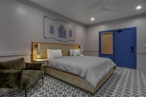 a bedroom with a bed and a chair and a blue door at Hotel Biloxi in Biloxi