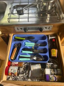 a drawer filled with cooking utensils in a drawer at Charmantes Oldtimer Wohnmobil in Aachen
