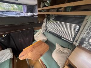 a room with two beds and a table in an rv at Charmantes Oldtimer Wohnmobil in Aachen