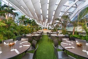 a restaurant with tables and chairs and a ceiling with windows at EAST Miami in Miami