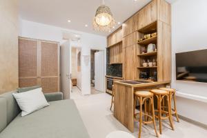 a kitchen and living room with a couch and a table at NooN Properties Santorini by PikHost in Palasë