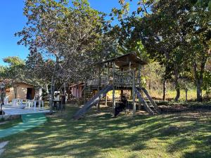 a playground with a slide in the grass at Pousada Recanto Guará Oficial in Pirenópolis