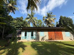 a house with palm trees in front of it at Lobo's Retreat in Kurunegala