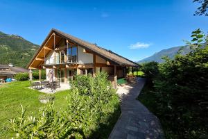ein Haus mit einem Weg davor in der Unterkunft Naturresort FiSCHERGUT - Lodge Wolfgangthal in St. Wolfgang