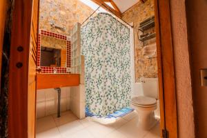 a bathroom with a toilet and a shower curtain at Hotel-Camping Takha Takha in San Pedro de Atacama +170 photos