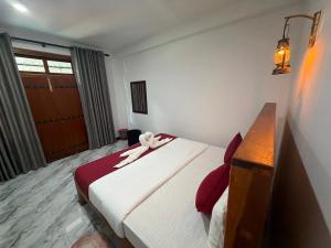 a hotel room with a bed with a towel on it at Duo Haven Inn Ella in Ella