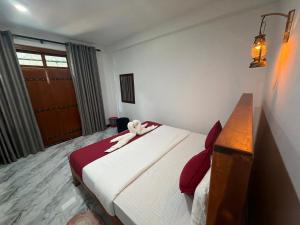 a bedroom with a bed with a teddy bear on it at Duo Haven Inn Ella in Ella +48 photos