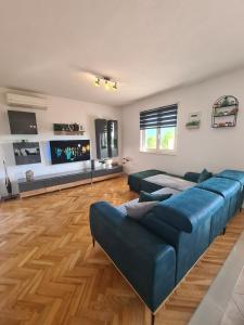 a living room with a blue couch and a television at Kuća za odmor Virgo in Opanci