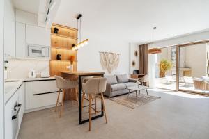 a kitchen and living room with a table and chairs at Boho Apartment with Sea View & Pool in Baošići