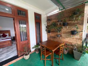 a wooden table and chairs on a porch with plants at Duo Haven Inn Ella in Ella