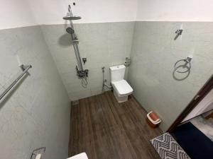 a bathroom with a toilet and a shower at Duo Haven Inn Ella in Ella
