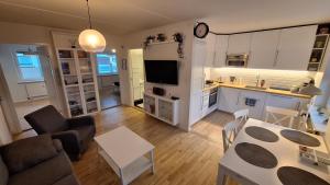 a living room with a table and a kitchen at Apartment Hundige in Greve