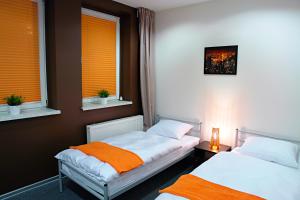 two beds in a room with two windows at Greyhouse in Jaworzno