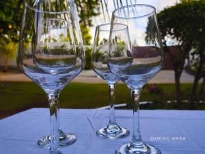 three wine glasses sitting on top of a table at The Clifftop Home Deluxe in Esperanza