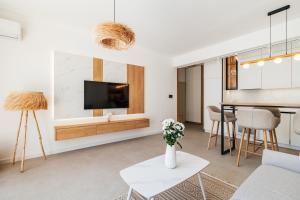 a living room with a tv on a wall at Boho Apartment with Sea View & Pool in Baošići