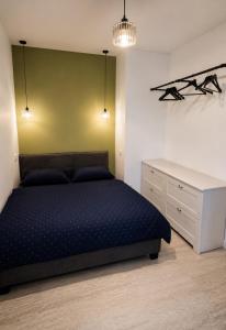 a bedroom with a bed and a white dresser at Apartmán na Rohu II in Malacky