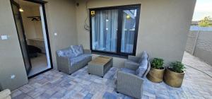 a patio with two chairs and a table at Apartmán na Rohu II in Malacky