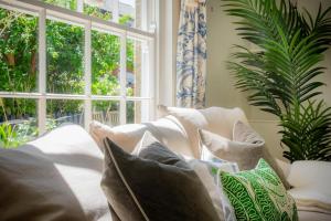 a couch with pillows sitting in front of a window at Christmas Cottage in Yarmouth