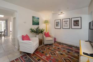 a living room with two chairs and a rug at Christmas Cottage in Yarmouth +22 photos