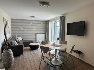 a living room with a table and a couch at Eastside 2 am Kurpark in Scharbeutz