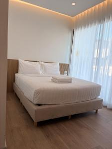 a large bed in a room with a large window at 2 Bed & 2 Bath Suite, 5th floor in Ban Bang Toei (1)