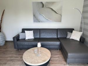 a living room with a couch and a table at Eastside 2 am Kurpark in Scharbeutz