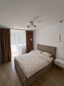 a bedroom with a large bed with a large window at Caro Central Apartament 3 Camere in Râmnicu Vâlcea